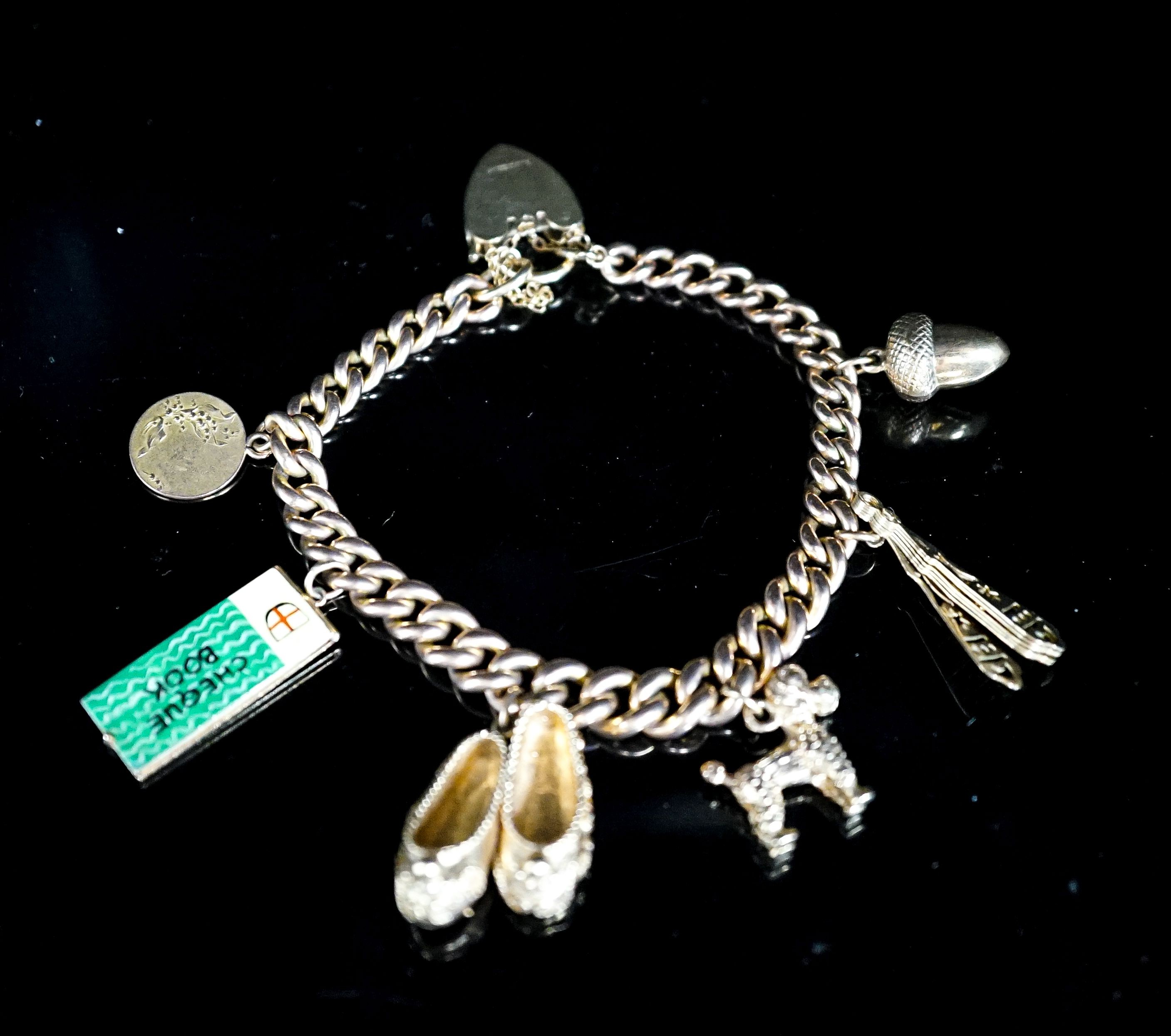 A 9ct curb link charm bracelet, hung with seven assorted charms, gross weight 38.8 grams.